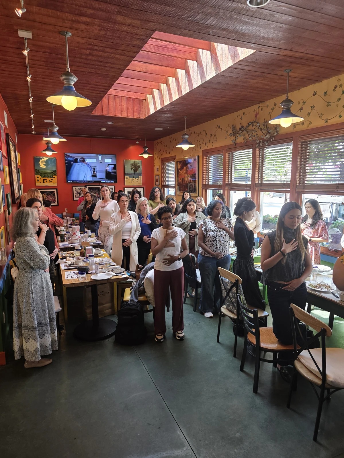 Women standing together with hands over their hearts at a FoundHER and FundHER gathering